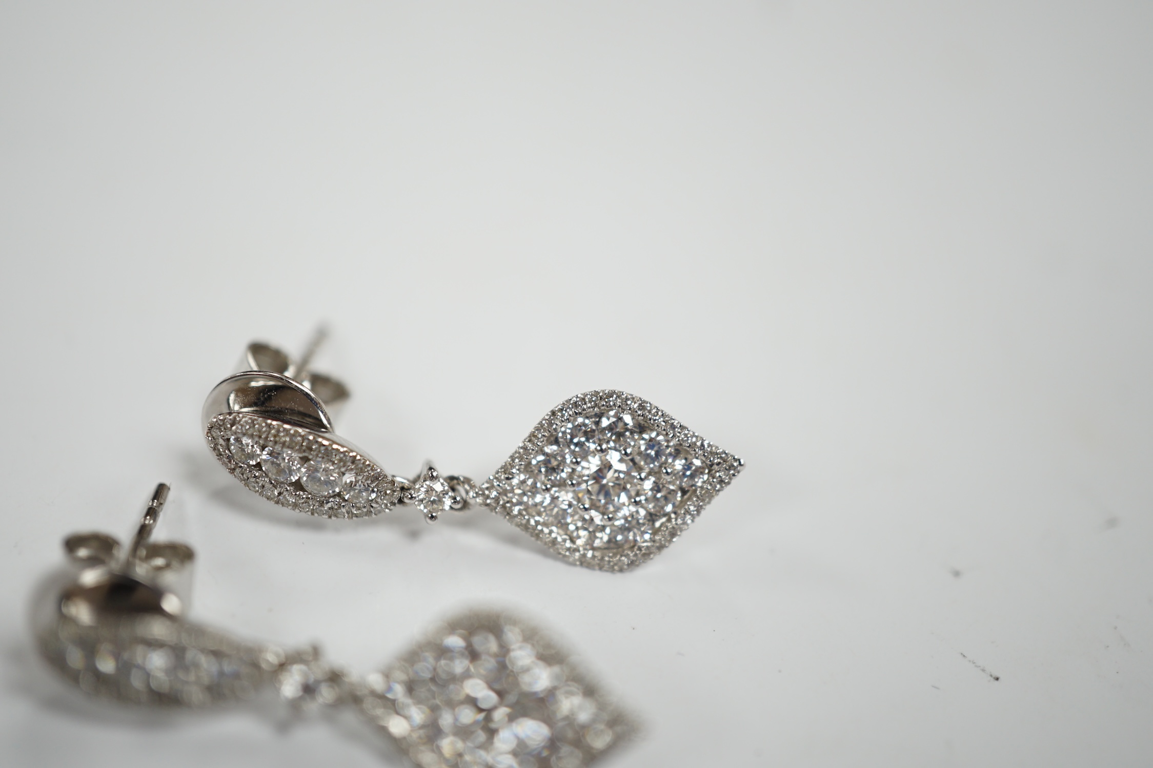 A modern pair of 750 white metal and diamond cluster set drop earrings, of elliptical form, 26mm, gross weight 4.1 grams.